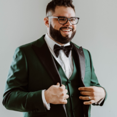 Tristan Bredehoft, co-owner of Café Rica, a family-owned coffee company and café in Battle Creek, dressed in a green tuxedo with a black bow tie.